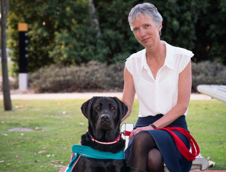 Elizabeth Barnes, CEO is seated with Bazza, our dog-assisted therapy dog.