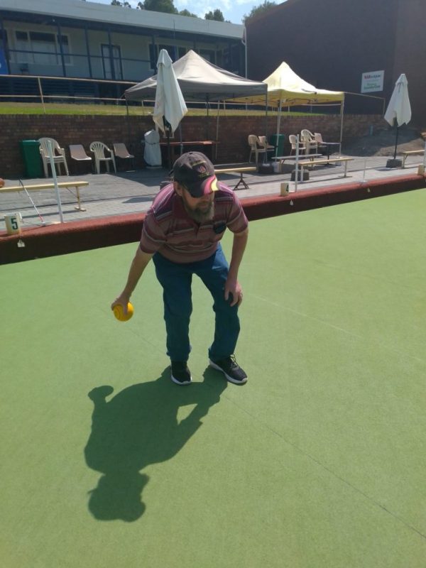 Phil is on a bowling lawn playing bowls