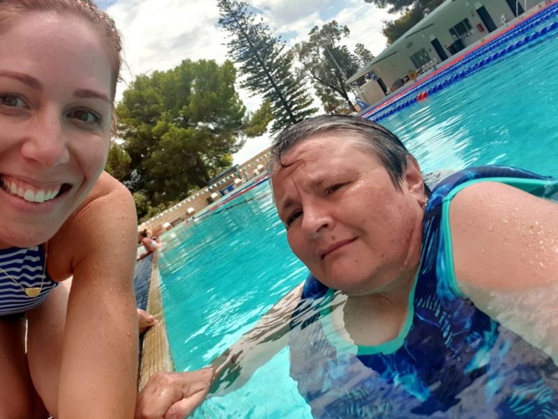 Image shows Felicity smiling with Bron in the outdoor pool.