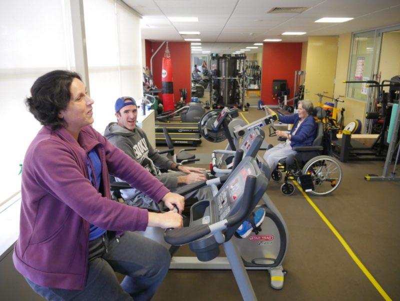 Narelle and Matt in the exercise clinic on the exercise bikes with another client in the background