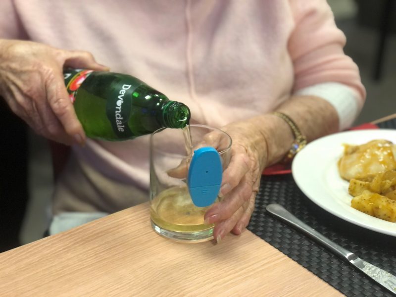Woman pours apple juice from a glass into a glass cup