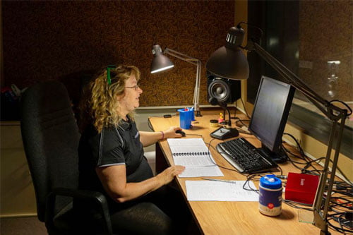 Susie sits in the recording studio, narrating a book 
