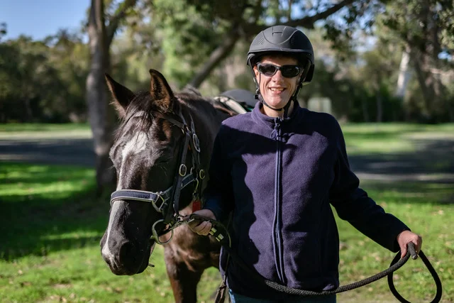Nicole stands alongside her horse