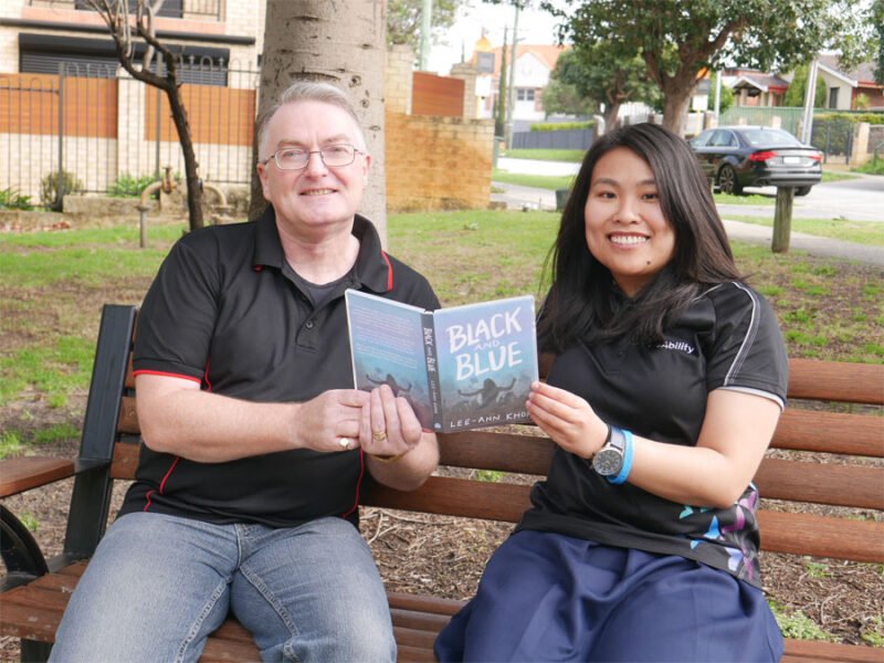 Ian and Lee-Ann sit on a bench in the park