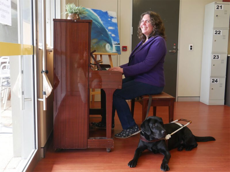 Claire at the piano with Willow by her feet