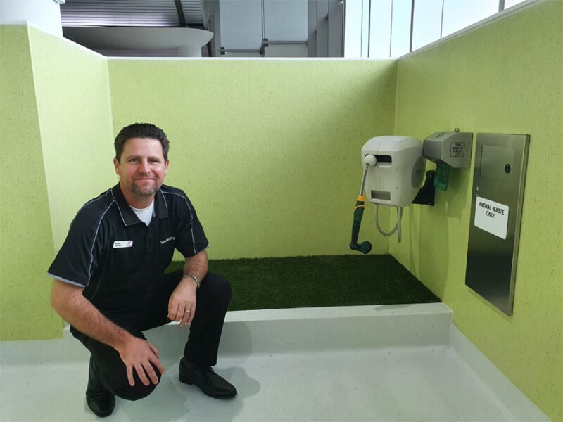 David kneeling beside grassed area off SARA facility