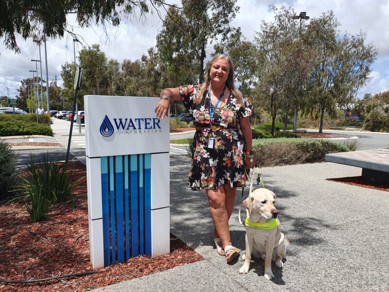 Annalise stands next to a water Corporation sign at the front of her office 